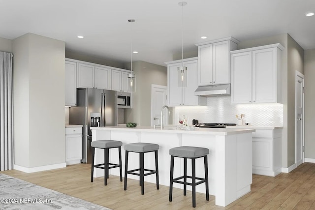 kitchen with decorative backsplash, stainless steel appliances, decorative light fixtures, white cabinets, and an island with sink