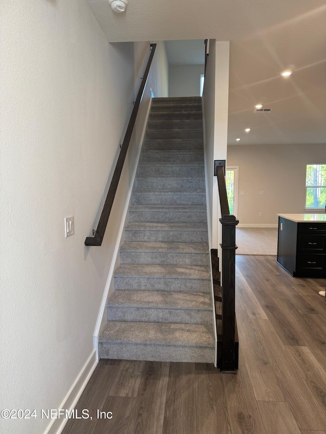 stairs featuring wood-type flooring