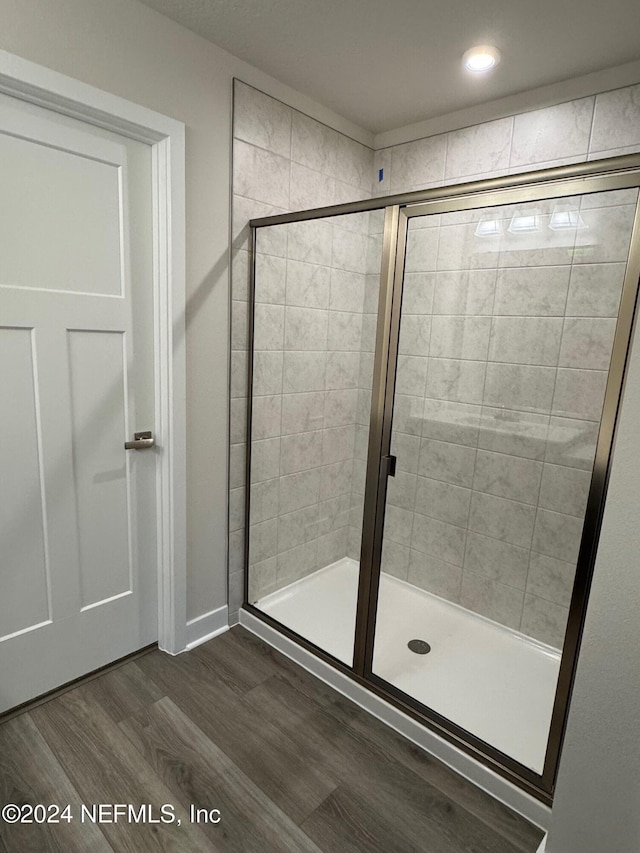 bathroom featuring hardwood / wood-style floors and walk in shower