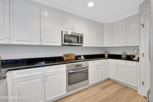2003 Windjammer Ln, Saint Augustine, FL 32084 - kitchen featuring stainless steel appliances, white cabinetry, and dark stone countertops