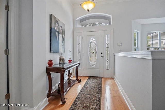 foyer featuring plenty of natural light, light hardwood / wood-style flooring, and ornamental molding