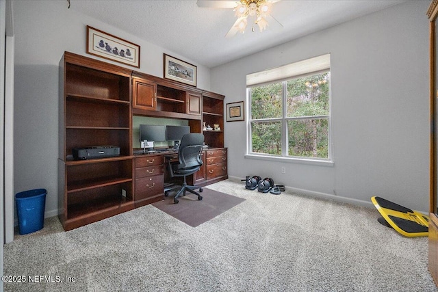 office space with light carpet, ceiling fan, and a textured ceiling