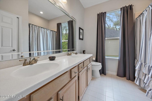 bathroom with toilet, tile patterned floors, and vanity