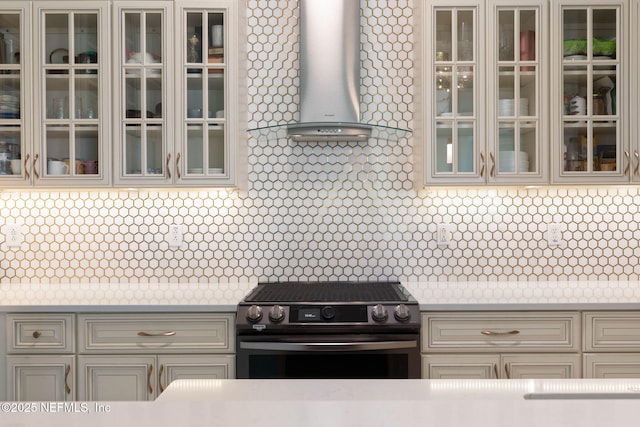 kitchen featuring wall chimney range hood and stainless steel gas range