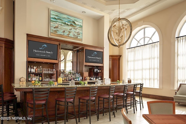 bar with light stone countertops and light tile patterned floors