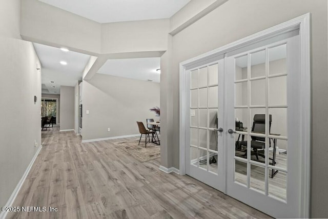 hallway with french doors and light hardwood / wood-style flooring