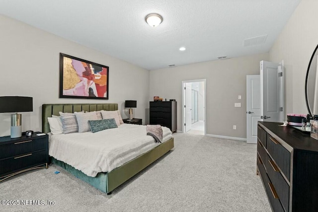 carpeted bedroom with a textured ceiling and ensuite bath