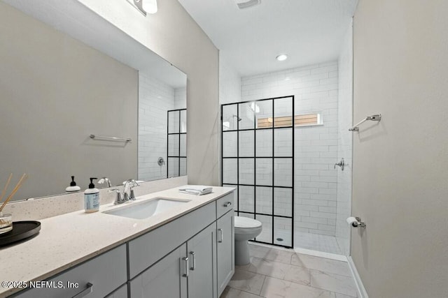 bathroom featuring tiled shower, vanity, and toilet