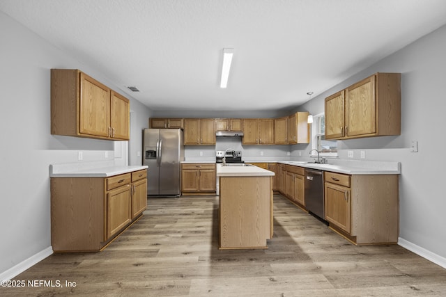 kitchen featuring sink, a center island with sink, light hardwood / wood-style flooring, and appliances with stainless steel finishes