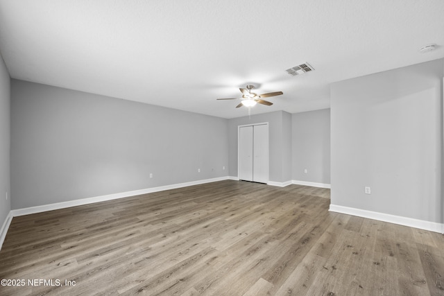 empty room with light hardwood / wood-style flooring and ceiling fan