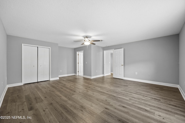 unfurnished bedroom featuring ceiling fan, dark hardwood / wood-style floors, and a textured ceiling