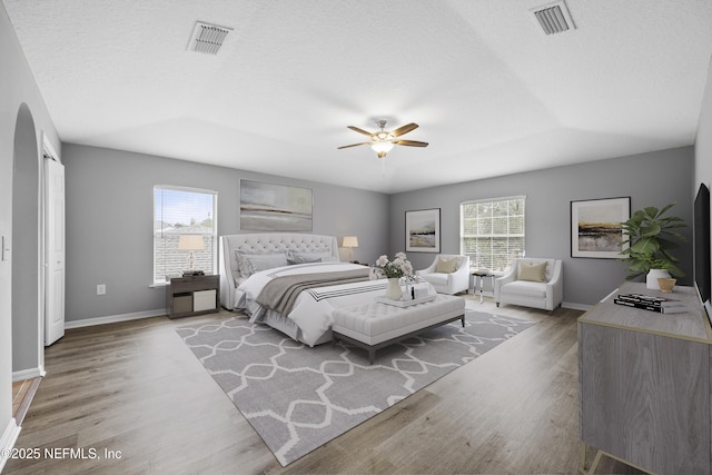 bedroom featuring ceiling fan, a textured ceiling, and light wood-type flooring