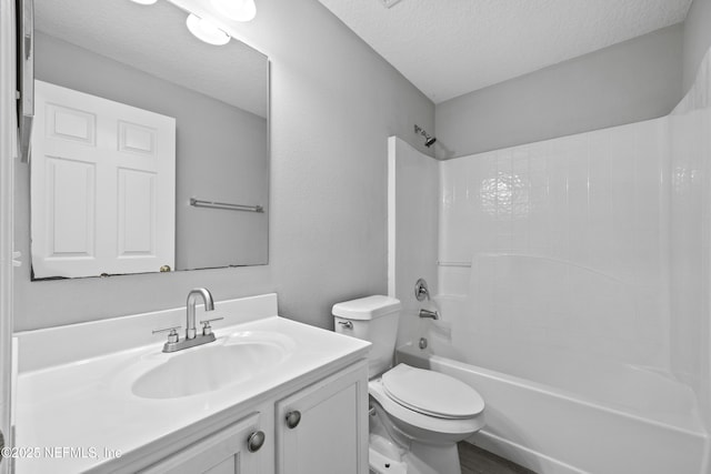 full bathroom featuring vanity, shower / tub combination, a textured ceiling, and toilet