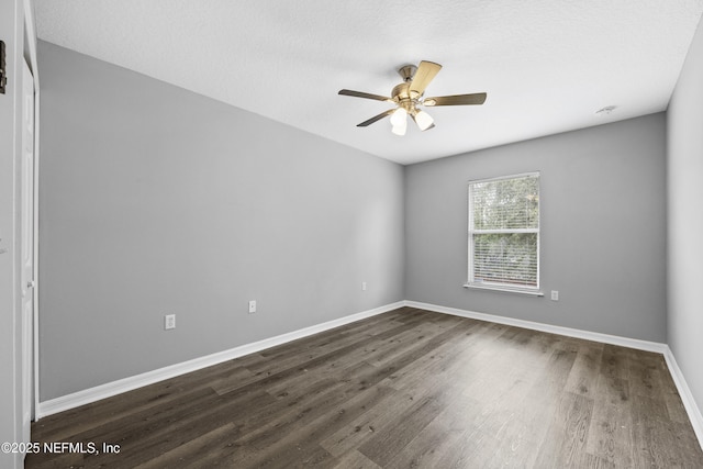 empty room featuring dark hardwood / wood-style flooring and ceiling fan