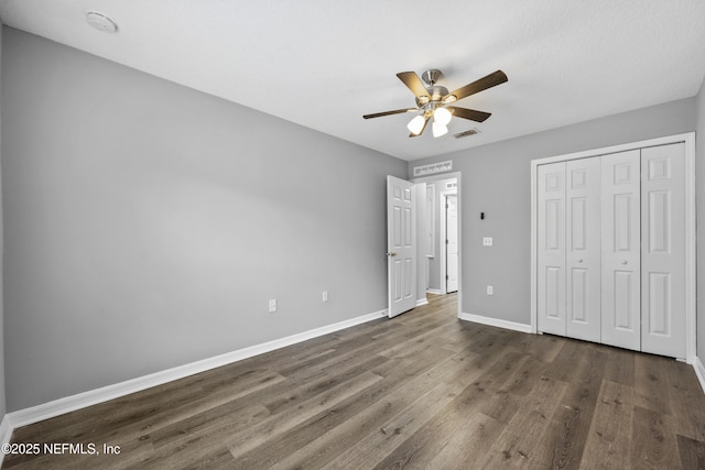 unfurnished bedroom featuring ceiling fan, a closet, and dark hardwood / wood-style floors