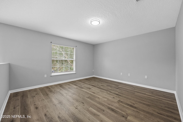 empty room with wood-type flooring and a textured ceiling