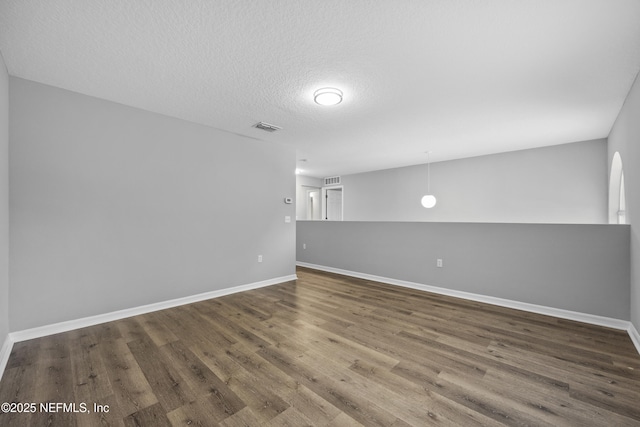 unfurnished room featuring hardwood / wood-style flooring and a textured ceiling