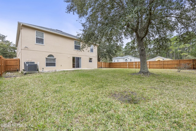 rear view of house featuring central AC and a lawn