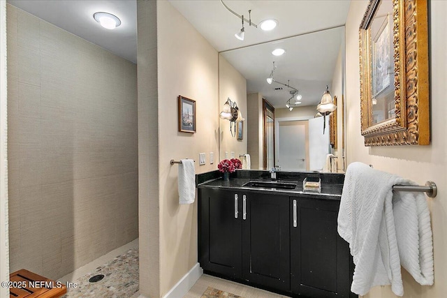 bathroom with vanity and tiled shower