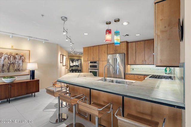 kitchen featuring appliances with stainless steel finishes, decorative light fixtures, sink, kitchen peninsula, and light tile patterned floors