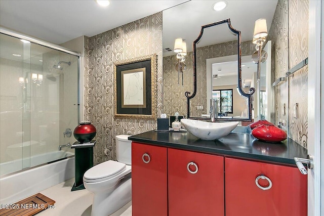 full bathroom featuring combined bath / shower with glass door, toilet, and vanity