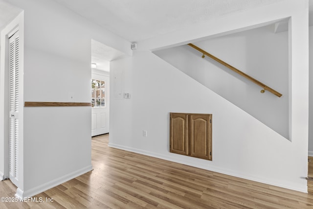 unfurnished living room featuring lofted ceiling and light hardwood / wood-style floors