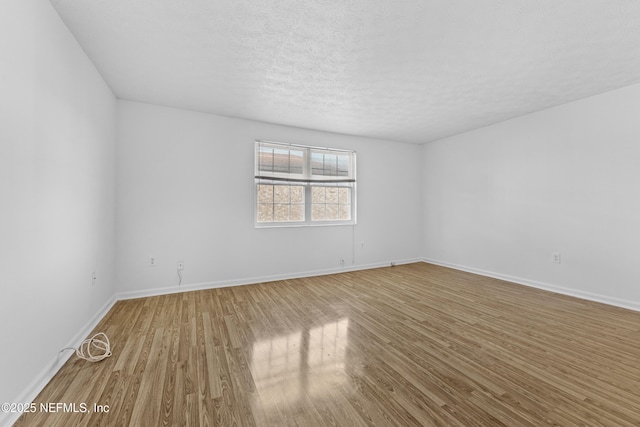 empty room featuring a textured ceiling and hardwood / wood-style flooring