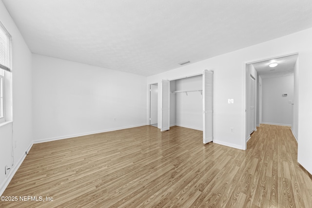 unfurnished bedroom featuring light wood-type flooring and a closet