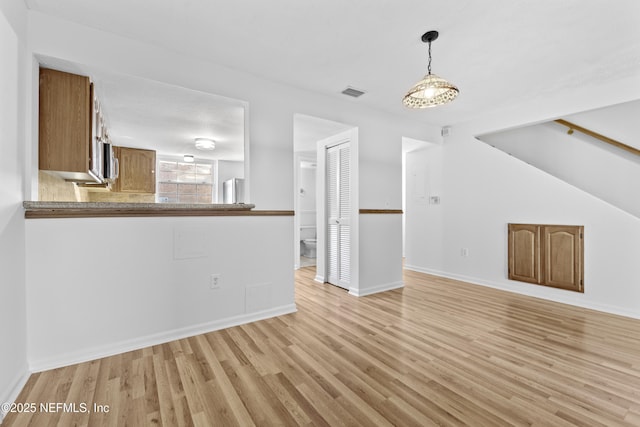 unfurnished living room with vaulted ceiling and light hardwood / wood-style flooring