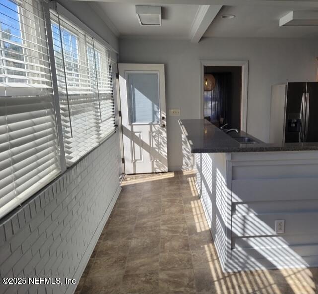 corridor with sink and beam ceiling