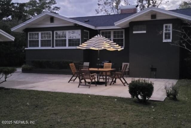 rear view of house with a patio area and a lawn