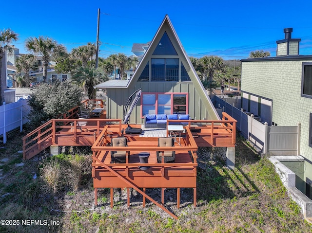 rear view of house with a wooden deck and an outdoor hangout area