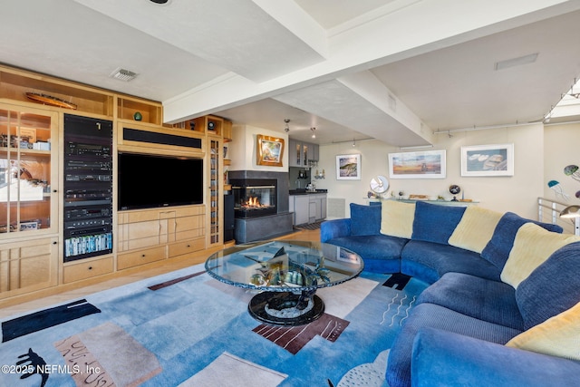 living room with beamed ceiling and a multi sided fireplace