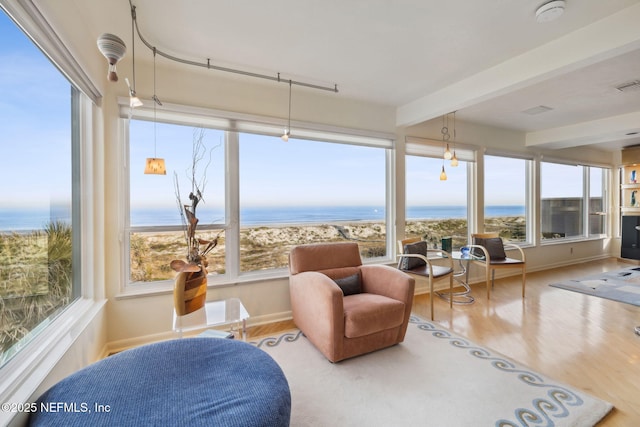 sunroom / solarium with a water view and beam ceiling