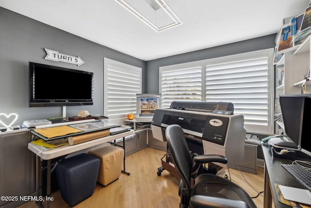 home office with light hardwood / wood-style flooring