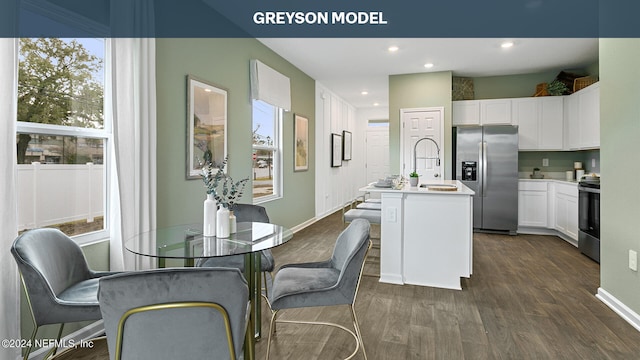 kitchen with stainless steel appliances, a kitchen island with sink, sink, white cabinetry, and plenty of natural light