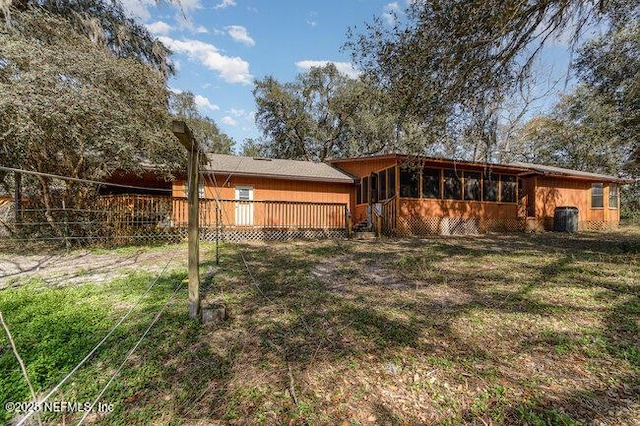 back of house with central AC and a yard