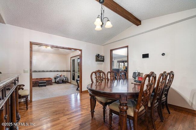 dining room with hardwood / wood-style flooring, vaulted ceiling with beams, a textured ceiling, and an inviting chandelier