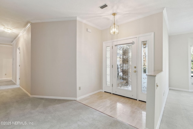 foyer entrance with ornamental molding, light carpet, and a notable chandelier