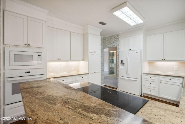 kitchen featuring white cabinetry, white appliances, decorative backsplash, and stone counters