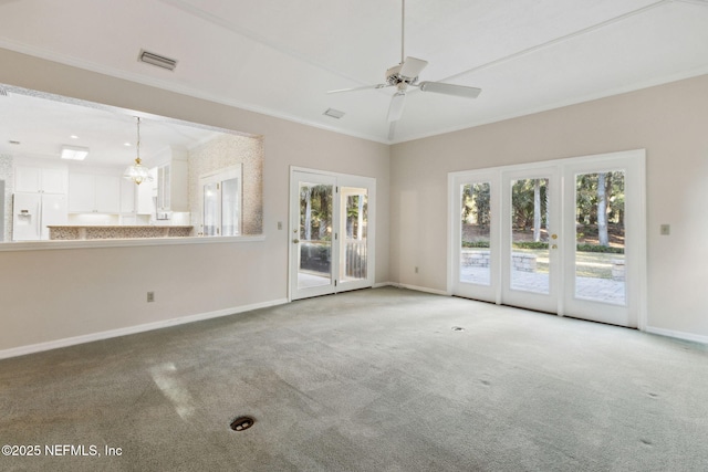 unfurnished living room featuring ornamental molding, carpet flooring, and ceiling fan with notable chandelier