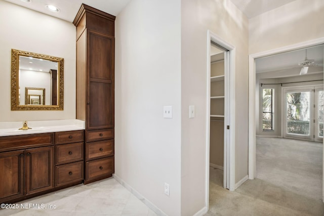 corridor featuring sink and light colored carpet