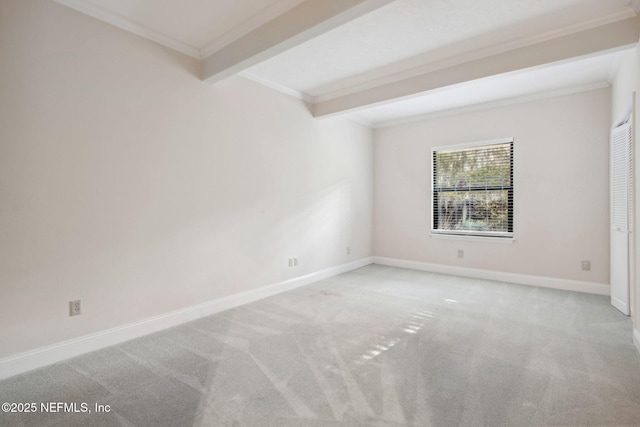 empty room featuring beamed ceiling, light colored carpet, and ornamental molding