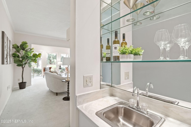 bar with carpet floors, a sink, baseboards, ornamental molding, and wet bar