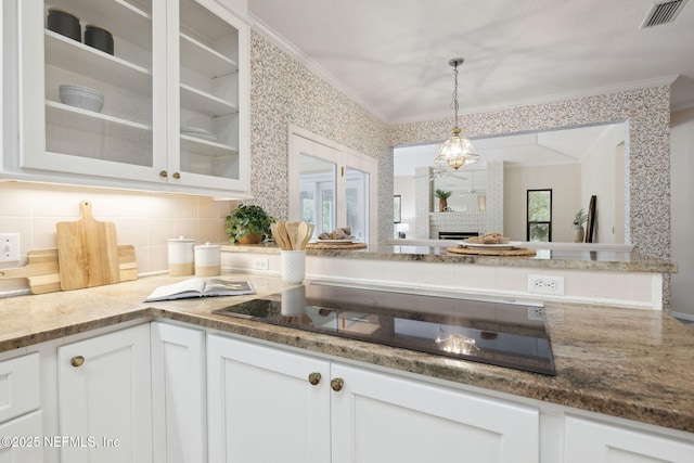 kitchen with visible vents, black electric stovetop, glass insert cabinets, and white cabinets