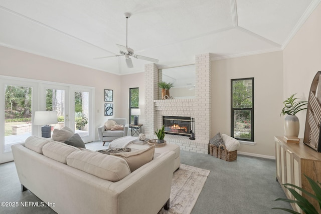 living room featuring ornamental molding, lofted ceiling, a fireplace, and ceiling fan