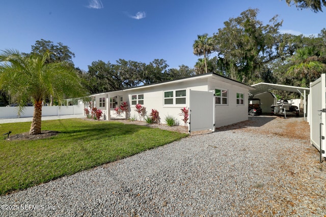 view of front of home with a carport and a front lawn