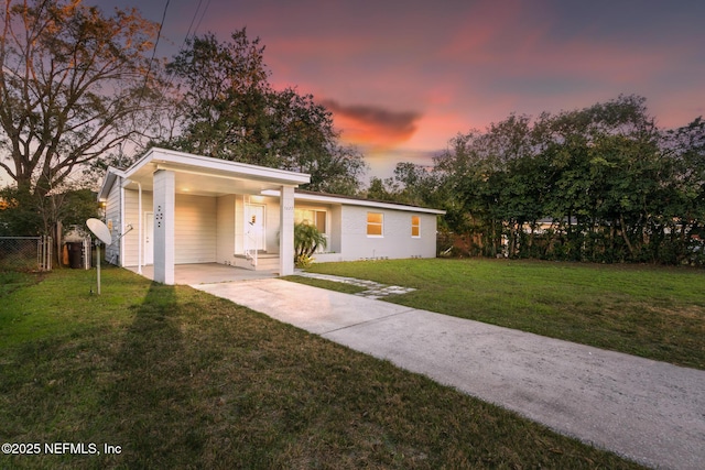 view of front facade with a carport and a lawn