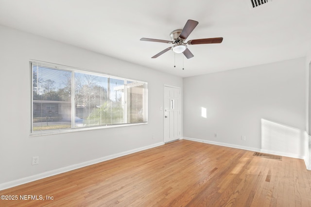 empty room with ceiling fan and light hardwood / wood-style flooring