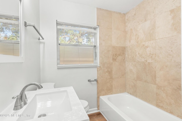 full bathroom with toilet, tiled shower / bath, and sink